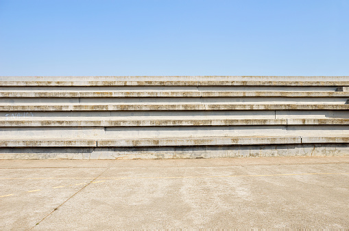 cement bleachers seats in an urban with blue sky background in sport centre