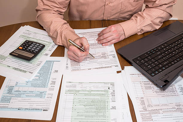 istock Filling 1040 tax form wtih laptop 515316034