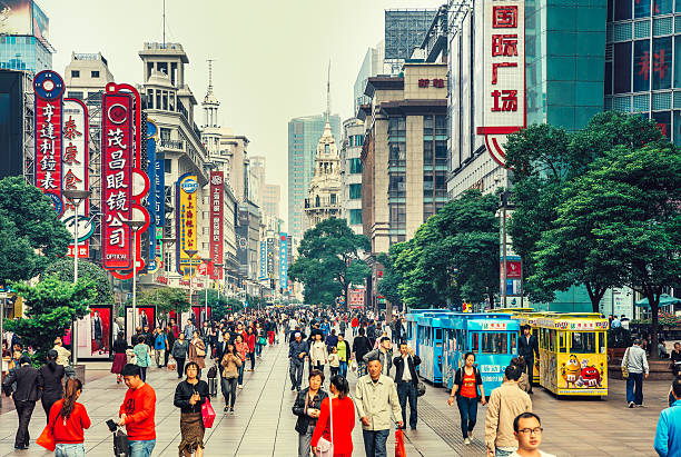 Nanjing Road in Shanghai, China Crowds walk below neon signs on Nanjing Road. The street is the main shopping district of the city and one of the world's busiest shopping districts.  jiangsu province photos stock pictures, royalty-free photos & images