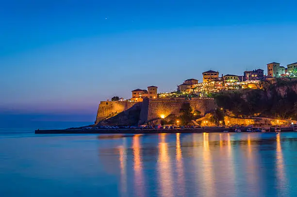 Photo of Ulcinj old town fortress at night with silky water and