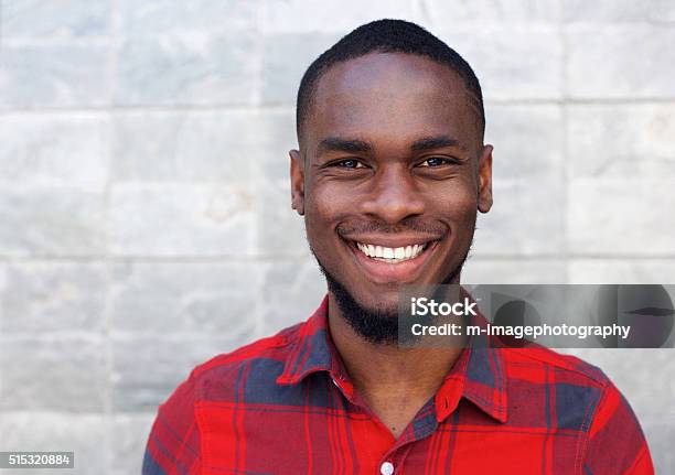 Hombre Africano Feliz Sonriente Contra La Pared Gris Foto de stock y más banco de imágenes de Retrato