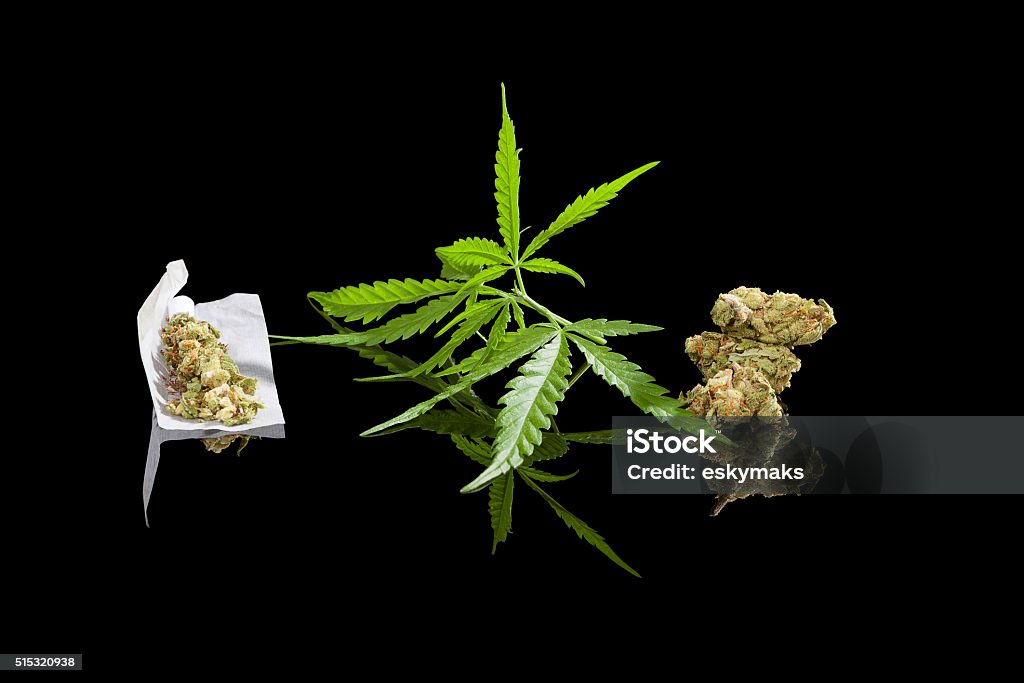 Marijuana background. Marijuana background. Cannabis cigarette joint, bud and hemp leaves isolated on black background. Addictive drug or alternative medicine. Black Background Stock Photo