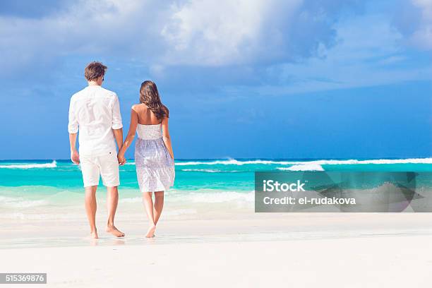 Joven Pareja Feliz En Blanco En La Playa Tropical De Miel Foto de stock y más banco de imágenes de Luna de miel