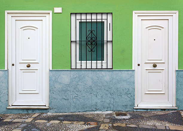 House facade with two white doors and a window in the middle