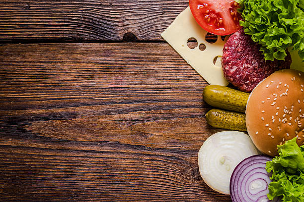 istock Ingredients for hamburgers on wooden table, border background 515376744