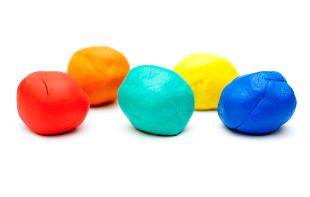 Colored plasticine on white background Five pieces of colored plasticine on white background. clay stock pictures, royalty-free photos & images