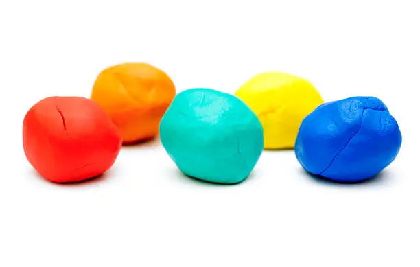 Five pieces of colored plasticine on white background.