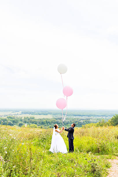 istock groom  and bride  with balloons  on  green field 515377306