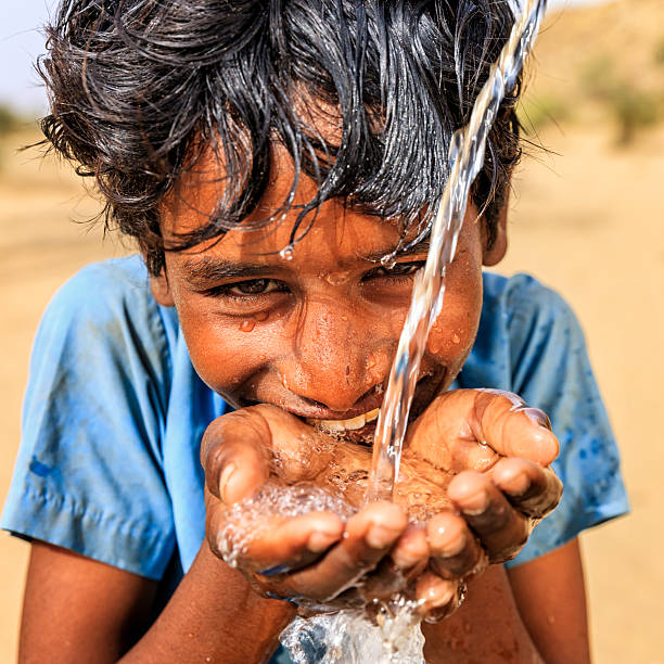 istock Indian young boy drinking fresh water in desert village 515377376