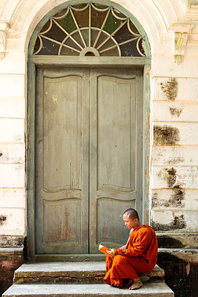 istock Buddhist  monk reading outside door 515379808