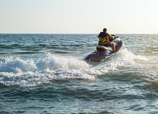 sylwetka człowieka na skutery wodne na morzu - łódź z napędem odrzutowym zdjęcia i obrazy z banku zdjęć