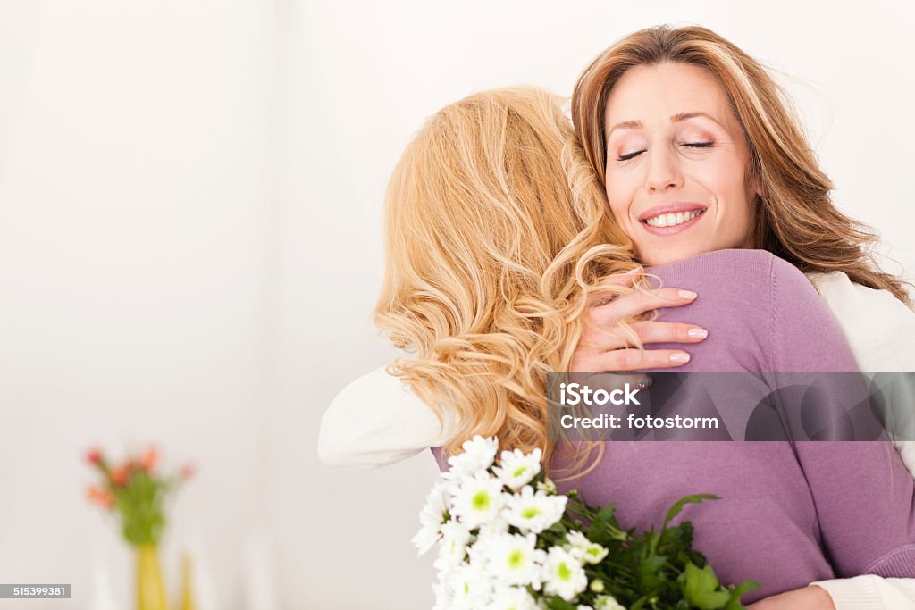 Flowers for loving mother Daughter gives her mother a bouquet of flowers. Mother's Day Stock Photo