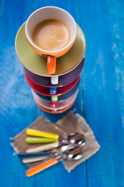 Tower of differently colored cups with coffee
