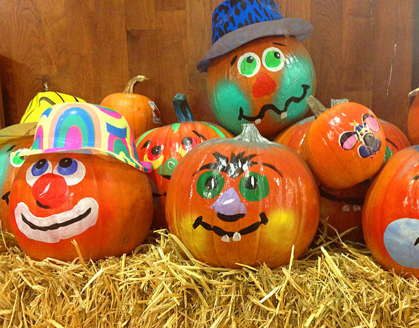 Halloween Decorated Pumpkins Decorated pumpkins on hay for Halloween. pumpkin decorating stock pictures, royalty-free photos & images