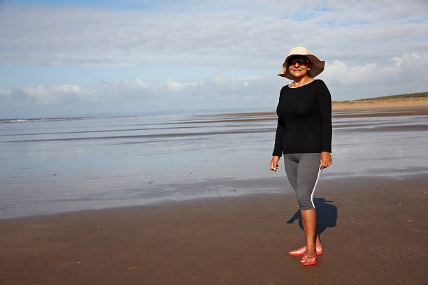 istock Mature hispanic woman walking on the seashore 515401365