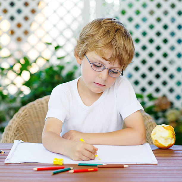 istock Little boy with glasses making homework at home 515432852