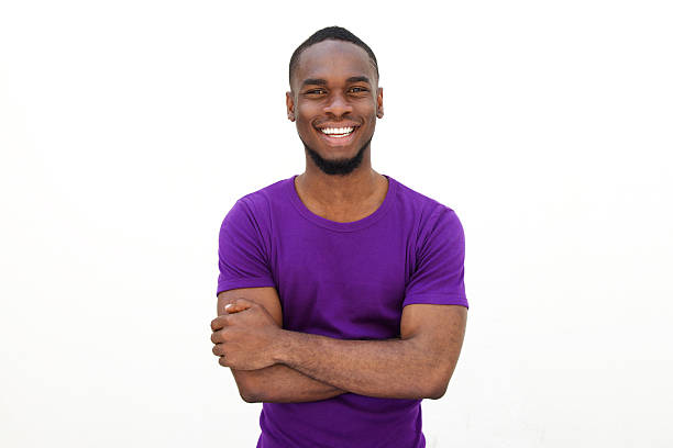 улыбается молодой человек в фиолетовый футболка - men shirt people black стоковые фото и изображения