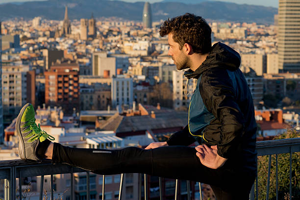 istock runner stretching leg looking at the city 515436236
