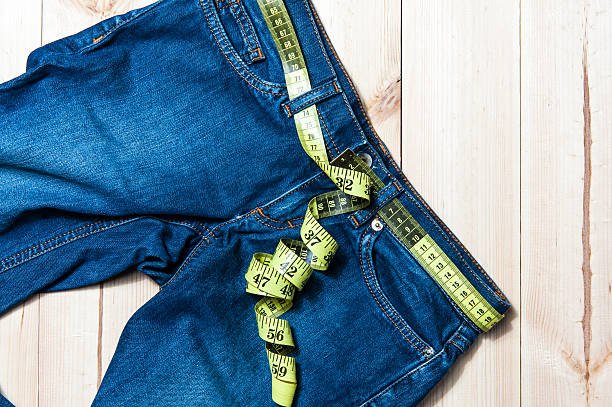istock jeans and centimeter on a wooden background 515437406
