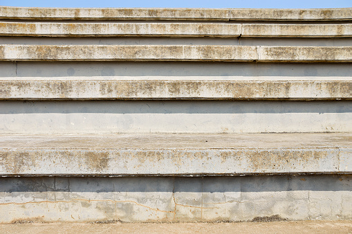 cement bleachers seats in an urban with blue sky background in sport centre