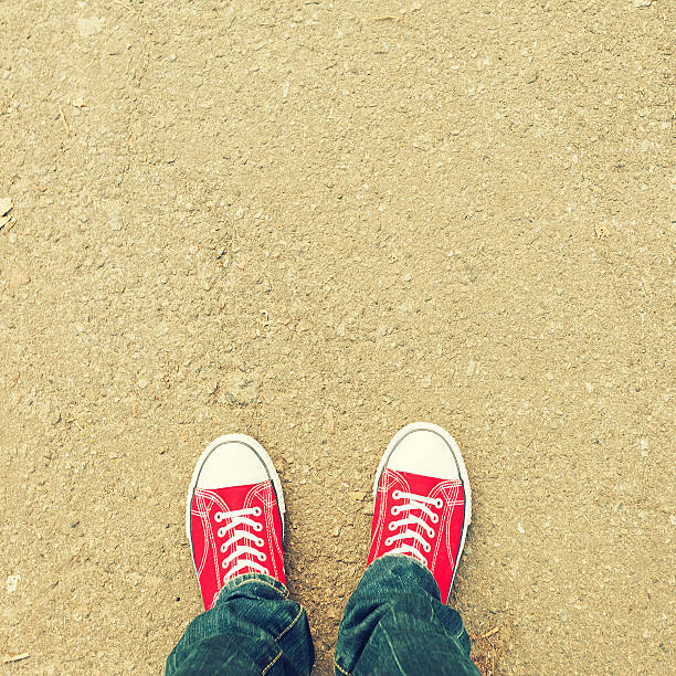 istock young man feet in red sneakers on cobbled road 515438904