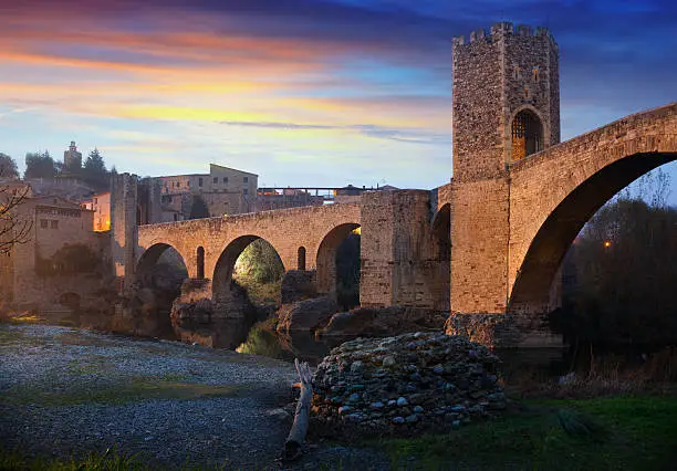 Medieval town with gate on bridge in evening. Besalu, Catalonia