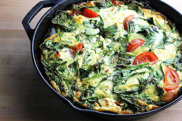 omelet A freshly made spring vegetable frittata in a cast iron pan frittata stock pictures, royalty-free photos & images