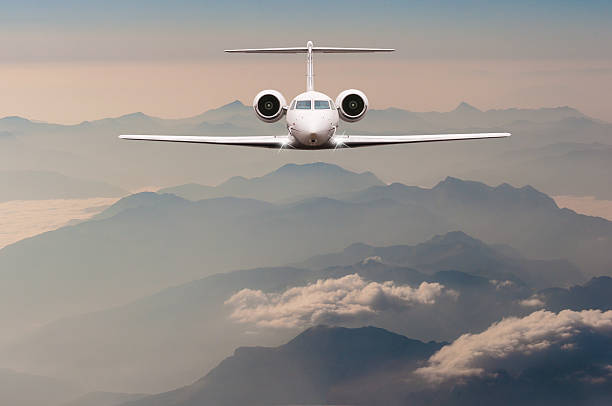 istock Luxury Airplane fly over clouds and Alps mountain on sunset 515446602