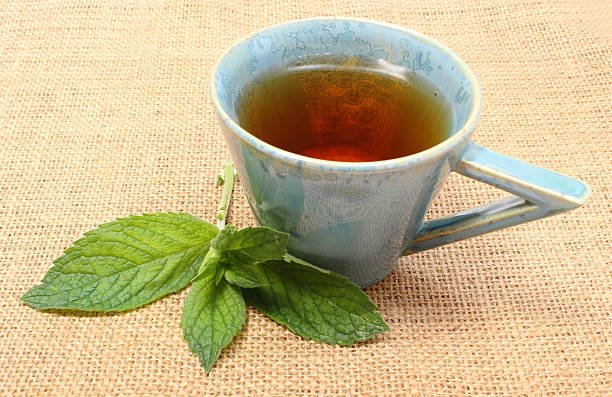 istock Fresh green mint and cup of beverage on jute canvas 515450635