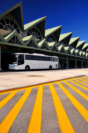 El Catey, Samaná province, Dominican republic: landside view of Samaná El Catey International Airport / Presidente Juan Bosch - AZS - pointed roofs, tour bus and yellow lines - photo by M.Torres