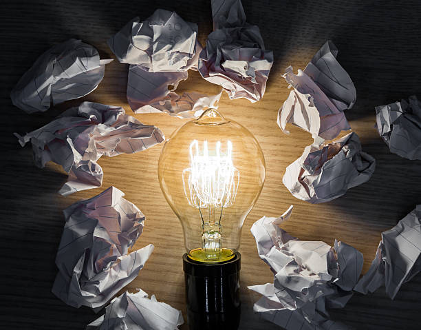 istock Light bulb with Crumpled paper on wood background 515453457
