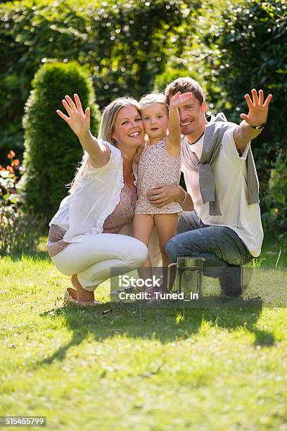 Mother Father And Daughter Embracing In Garden Stock Photo - Download Image Now - Adult, Affectionate, Blond Hair