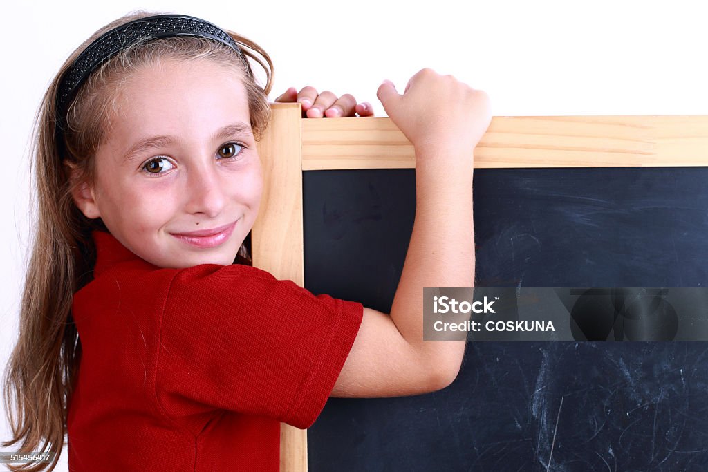 Study Little girl in front of empty chalkboard.. 6-7 Years Stock Photo