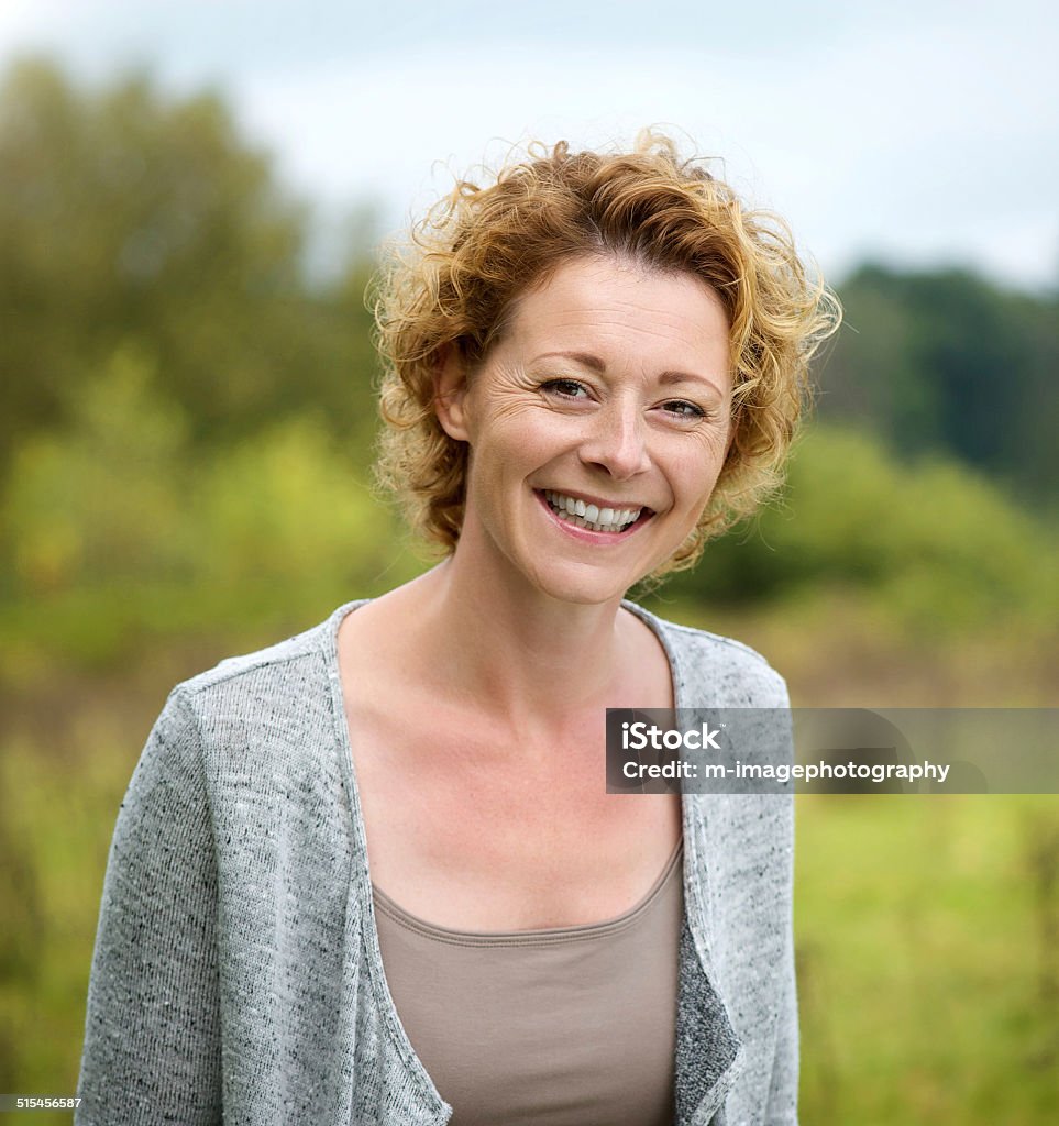 Beautiful mature woman smiling in the park Close up portrait of a beautiful mature woman smiling in the park Women Stock Photo