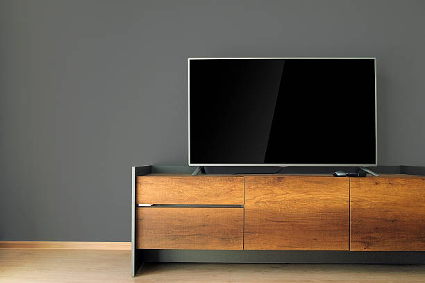 istock Led TV on TV stand with black wall 515473604