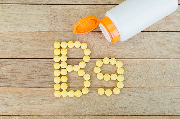 istock Yellow pills forming shape to B9 alphabet on wood background 515474454