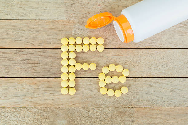 istock Yellow pills forming shape to Fe alphabet on wood background 515475200