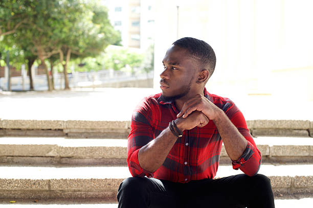 istock Pensive young african man sitting on steps 515475582