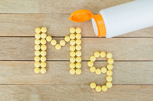 istock Yellow pills forming shape to Mg alphabet on wood background 515475626