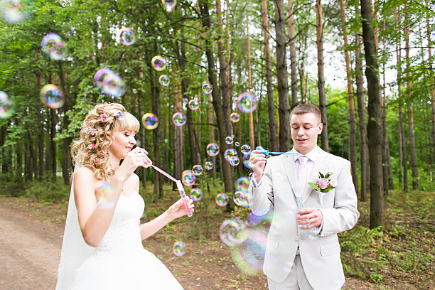 istock beautiful wedding couple blowing bubbles 515485080