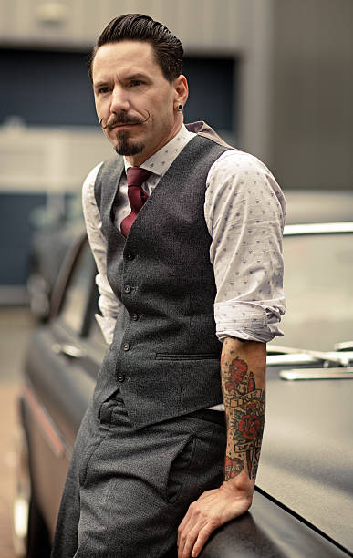 istock Retro dressed man with moustaches standing next to car 515515281