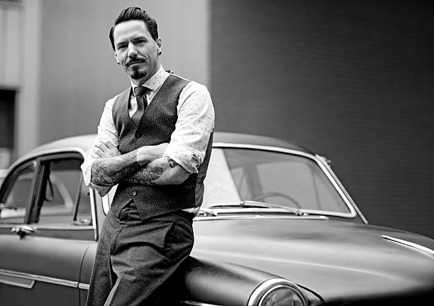 istock Retro dressed man with moustaches posing next his car 515515337