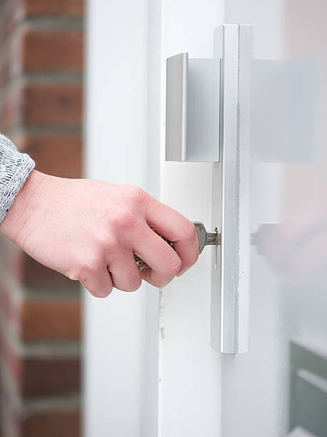 istock Female hand holding key inserting in door lock 515518223