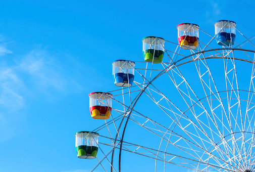 Ferris Wheel on a fairground set against a blue and partial cloud sky