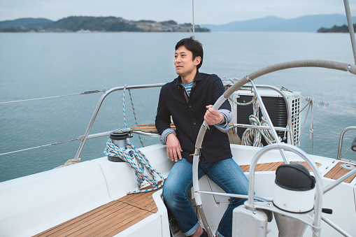 Man sat relaxing on a luxury yacht. Okayama, Japan. March 2016