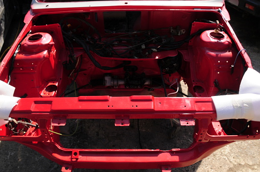 Wide angle image of the engine bay of a restored car shell.