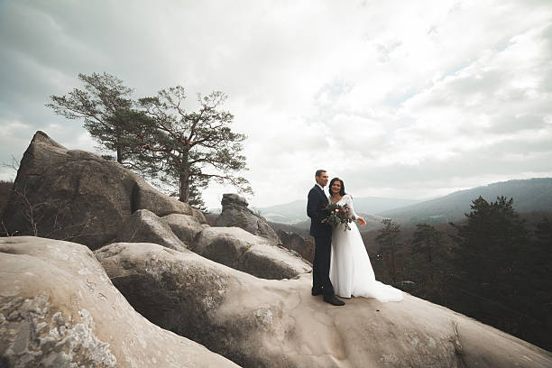 istock Gorgeous bride, groom kissing and hugging near the cliffs with 515519450