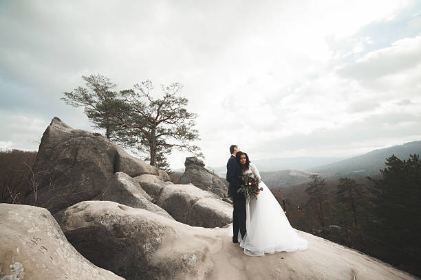istock Gorgeous bride, groom kissing and hugging near the cliffs with 515519552