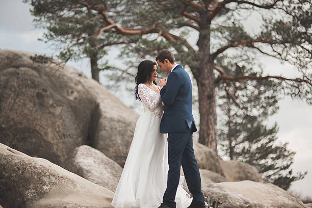 istock Gorgeous bride, groom kissing and hugging near the cliffs with 515519960