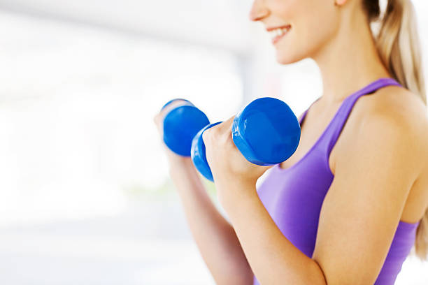 istock Woman Lifting Dumbbells In Gym 515519977